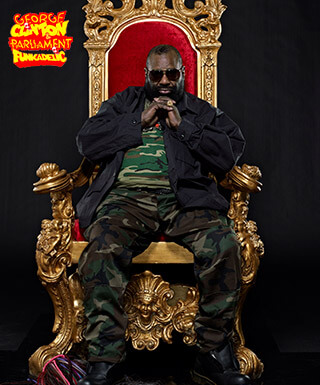 Singer George Clinton seated on a red and gold throne.