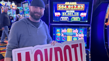 Man holding jackpot sign in front of $17,000 Jackpot.