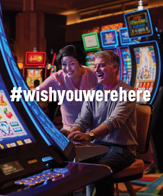 couple at slot machine with text "#WishYouWereHere"