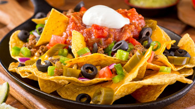 Nachos with olives, salsa and sour cream