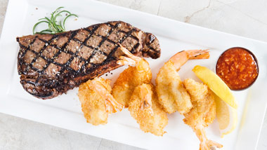 New York Strip Steak with fried shrimp, lemon and cocktail sauce